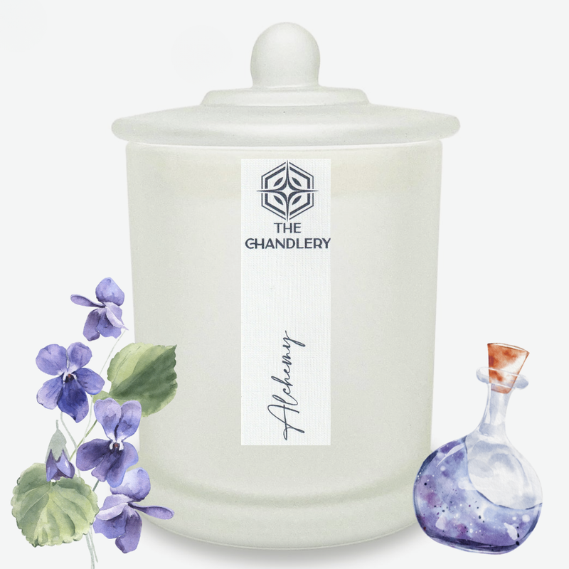 Alchemy apothecary candle in frosted glass with lid, illustrated with violets and a potion bottle