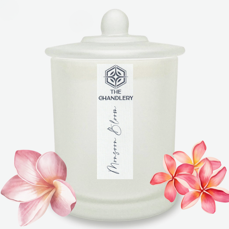 Monsoon Bloom apothecary candle in frosted glass with lid, illustrated with pink frangipani