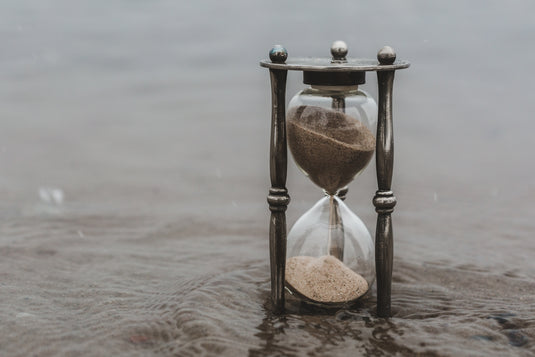 Hourglass standing in shallow still water
