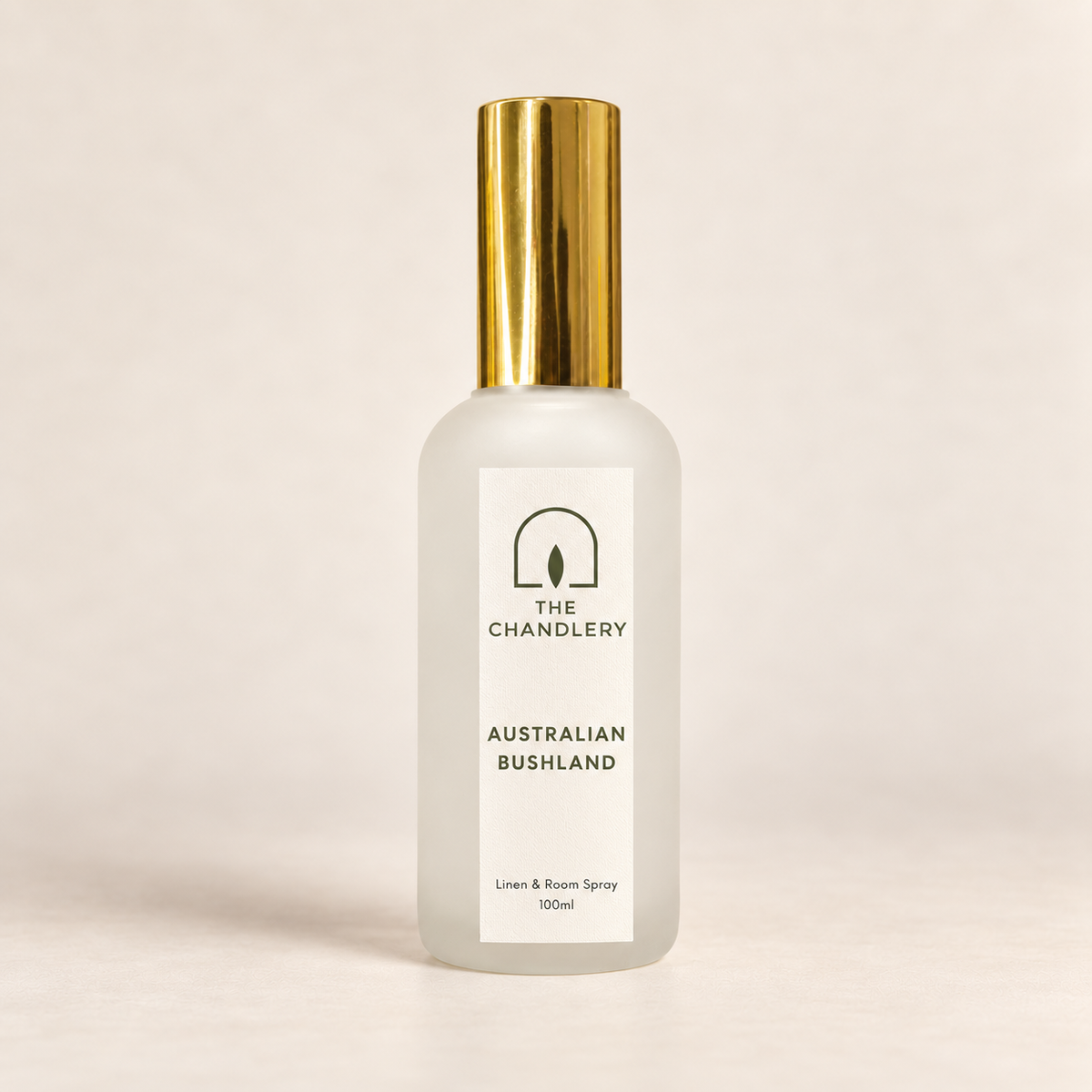The Chandlery Australian Bushland room spray in a frosted glass bottle with a gold spray top, photographed against a soft neutral backdrop.