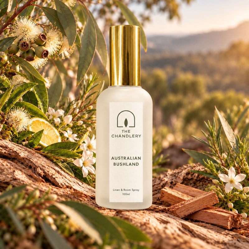 Australian Bushland room spray surrounded by eucalyptus leaves, native blossoms and weathered timber in a bushland setting.