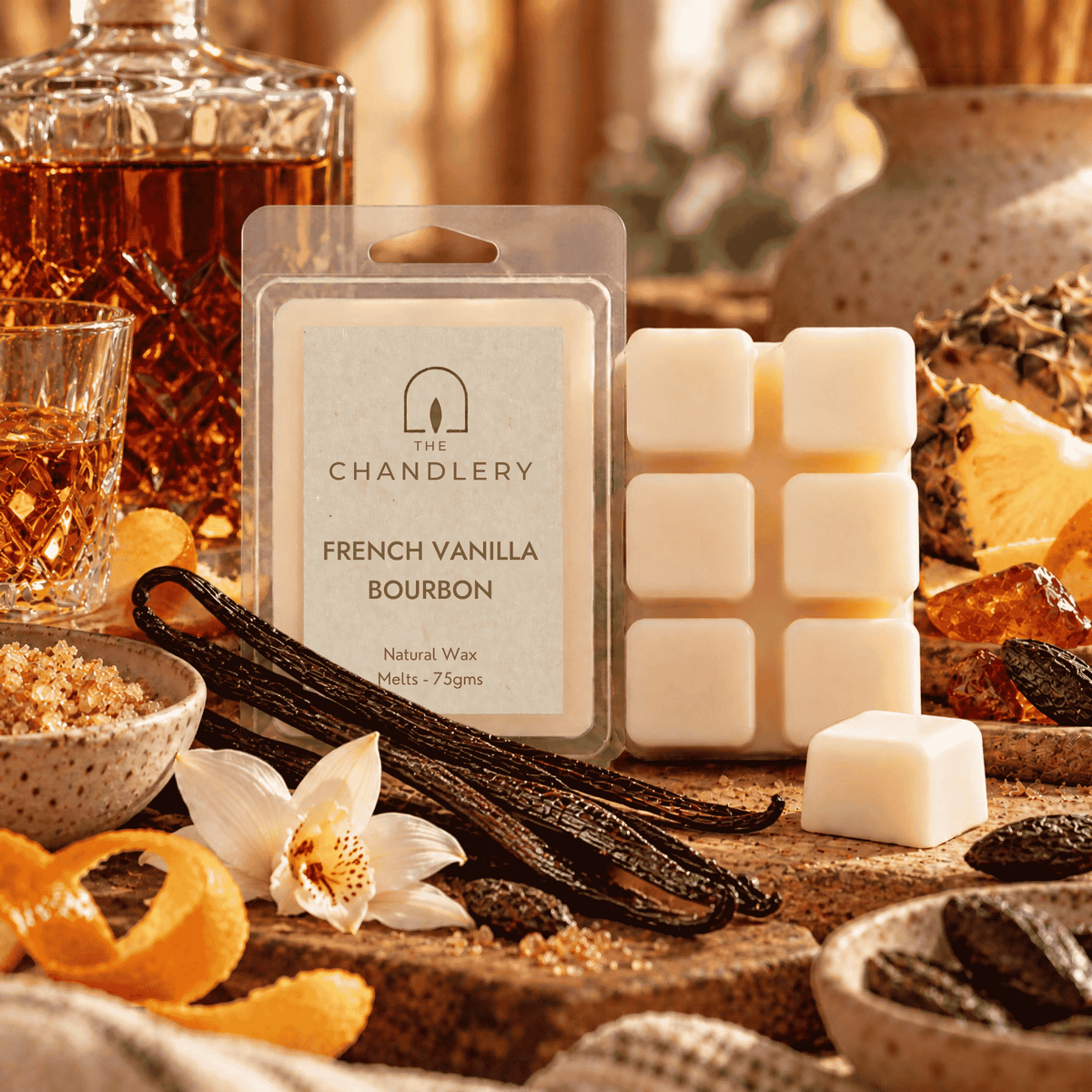 French Vanilla Bourbon wax melt packet and ivory six-cube bar with a loose cube, vanilla pods, orange peel and amber glass.