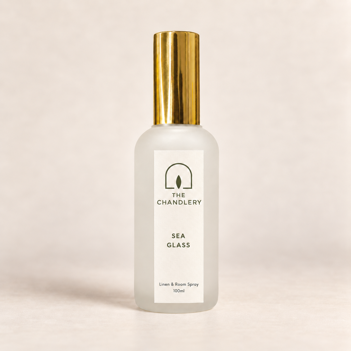 The Chandlery Sea Glass room spray in a frosted glass bottle with a gold spray top, photographed against a soft neutral backdrop.