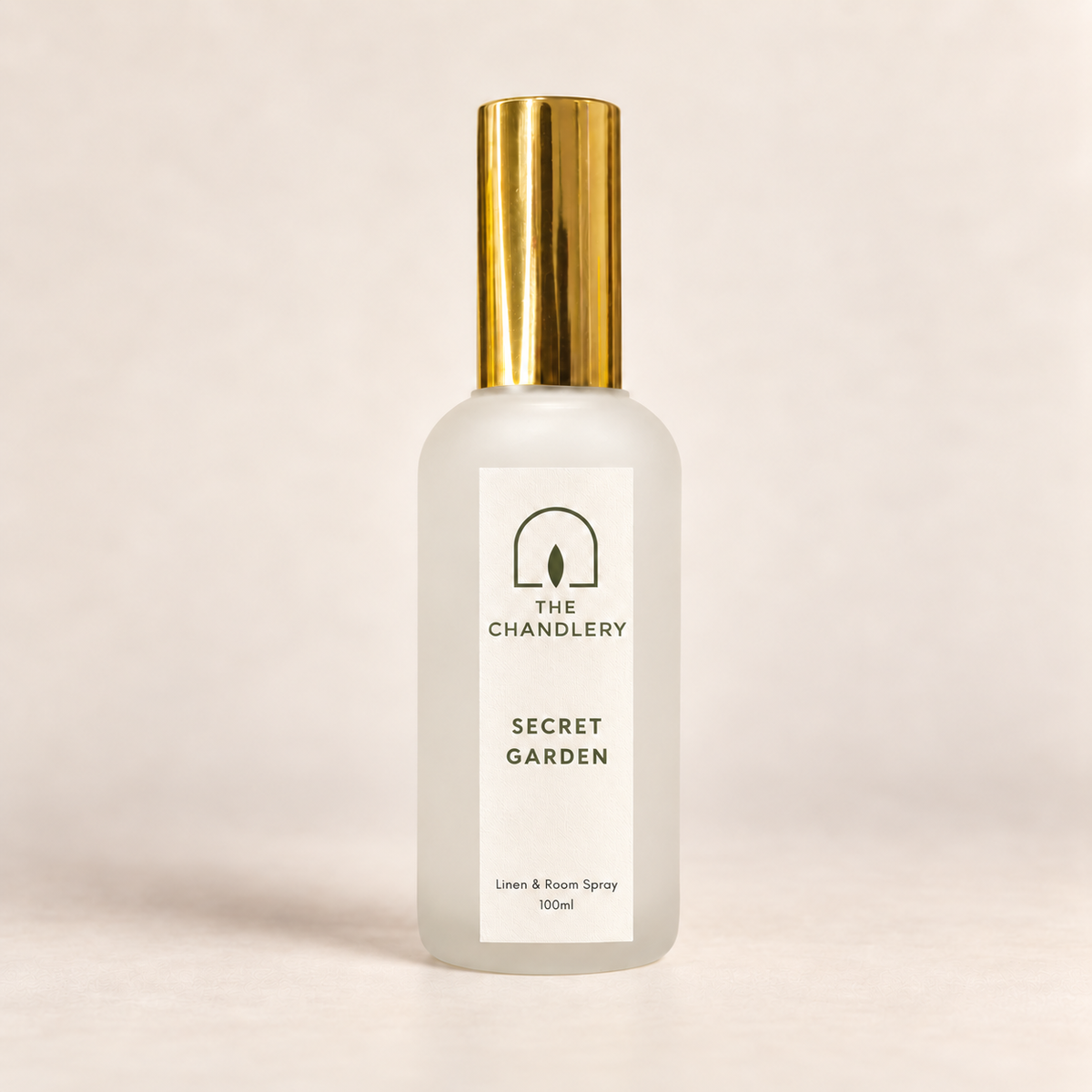 The Chandlery Secret Garden room spray in a frosted glass bottle with a gold spray top, photographed against a soft neutral backdrop.